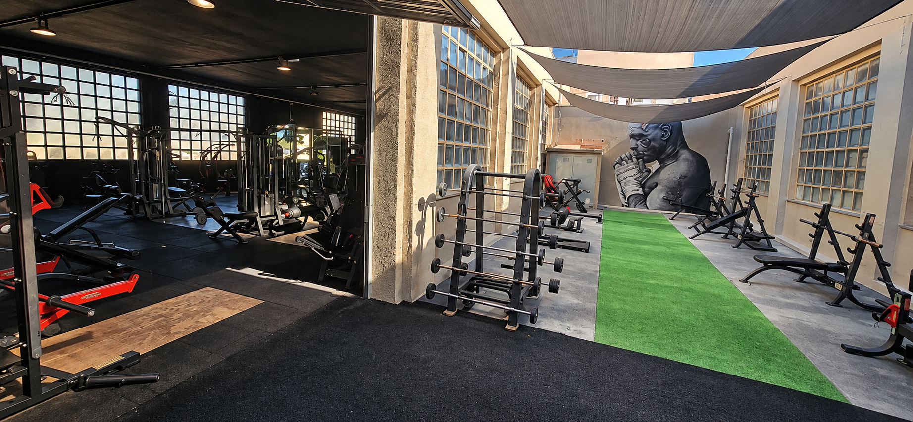 Zona exterior de entrenamiento de Steel, con césped, equipamiento y mural